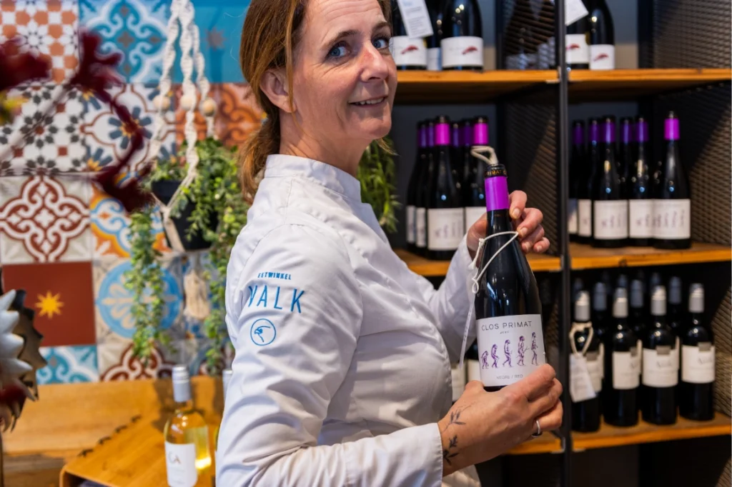 Collega Petra wie een fles rode wijn vastheeft.